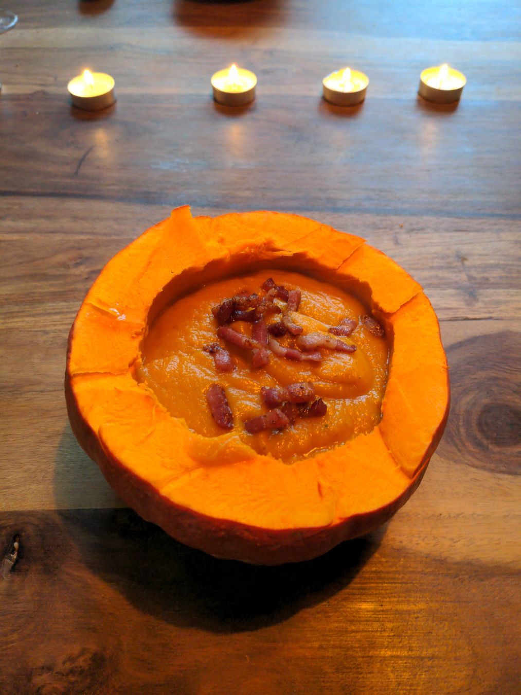 die untere Hälfte eines Kürbis' mit Kürbissuppe gefüllt